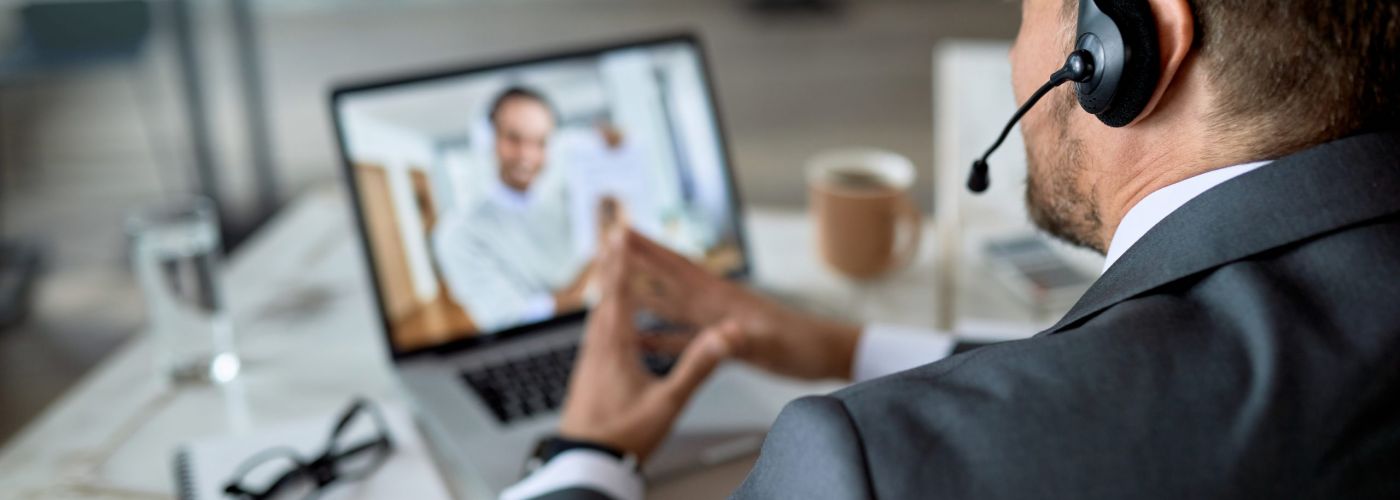 Imprenditore al lavoro con il laptop durante una riunione aziendale online in ufficio